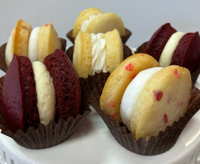 Red velvet and vanilla whoopie pies in brown paper cups